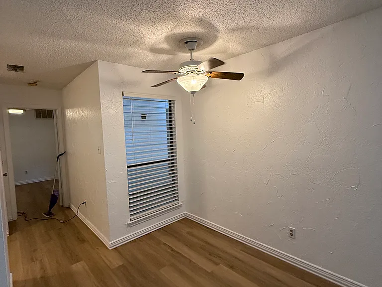 Dining area with lighted ceiling fan.
