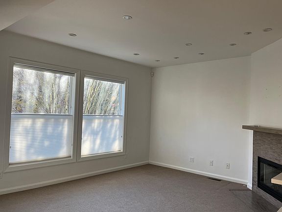 Living room with gas fireplace that flows to the dining room, kitchen, entry and stairs to third level. .