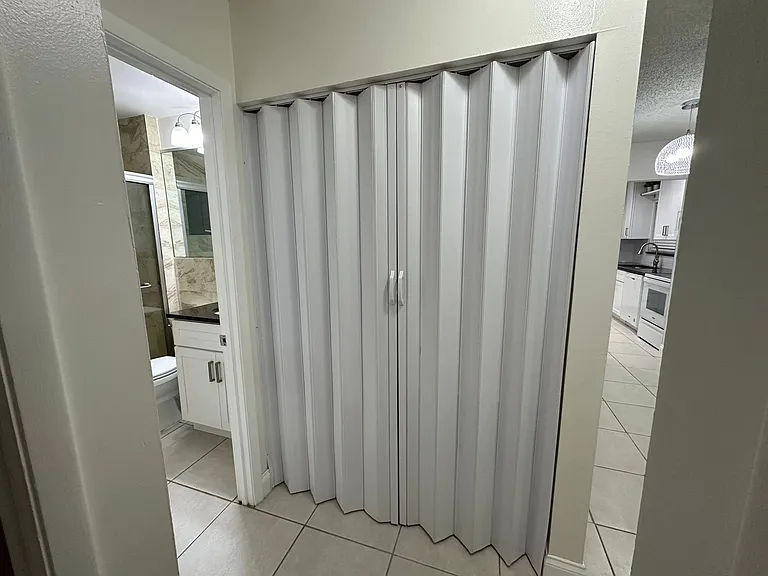 LAUNDRY AREA,
ENCLOSED BY ACCORDION DOORS.