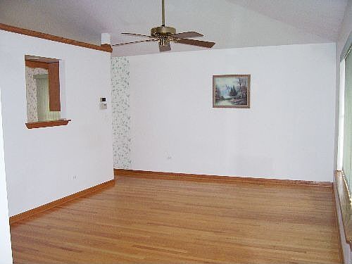 Spacious Front Room With Hardwood Floors and Look Through into Kitchen