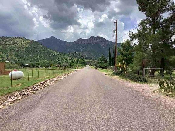 House is on the right side, and gate/driveway.