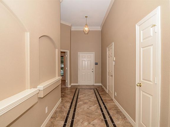 Magnificent hallway showing the front door leading into the home with custom designed floor tiles, arches and moulding