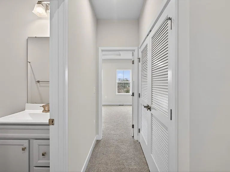 View of the master bedroom from the hallway; laundry area behind the double doors