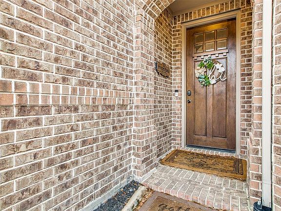 Beautiful brick entry with wood and glass front door to allow in that natural sunlight