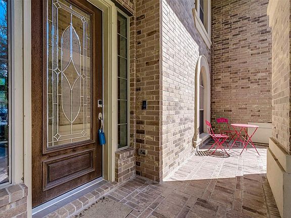 Lovely brick entrance with covered porch and wood and leaded glass door.