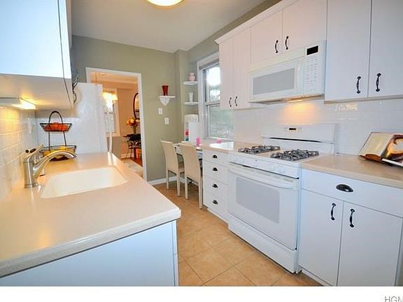Updated Kitchen with Corian counter tops, a breakfast bar and appliances include a dishwasher, microwave, range and refrigerator
