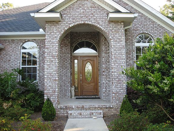 Tiled covered entrance and mahogany door with half moon window greet you.