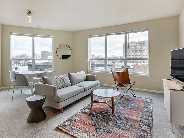 Furnished+ apartment homes come outfitted with a sofa, side chair, side table, coffee table, TV stand and 50" Television (Representative Image exact items and style of furnishings may vary)