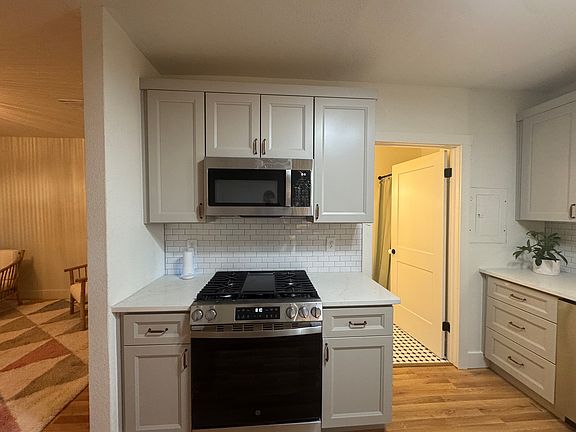 Brand New GE gas range with 4 burners and center griddle. Great for pancakes and burgers. New GE over range Microwave oven. (The door leads into the renovated bathroom)