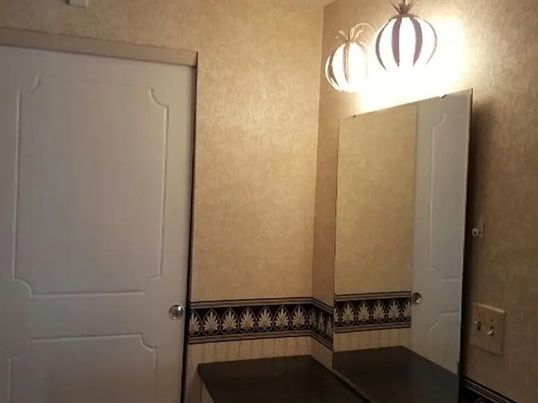 Master bedroom powder room, double doors closet and not seen to left, single door walk-in closet. Behind camera, door to master bathroom. To the right, entry to master bedroom area and doors to pool area as well.