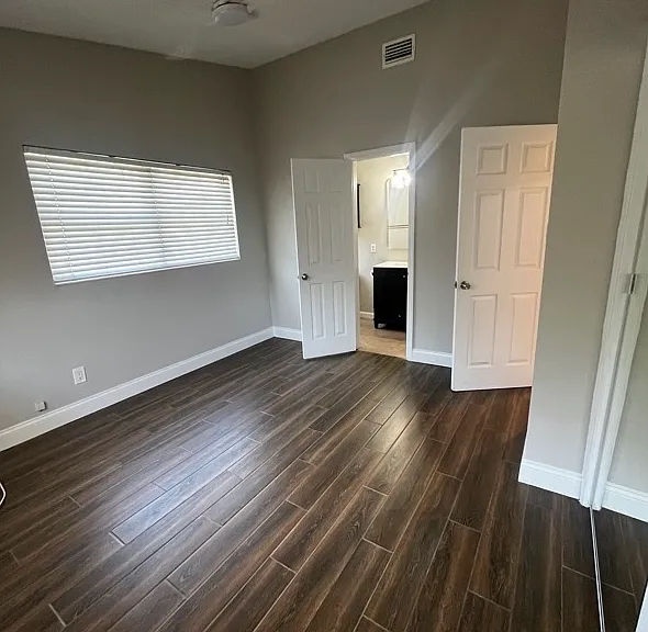 Primary Bedroom: Ceiling fan with light, closet, wood look porcelain flooring, attached full bath.