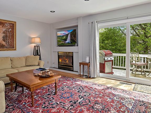 Main level Living Room w/ gas fireplace leading to outdoor deck