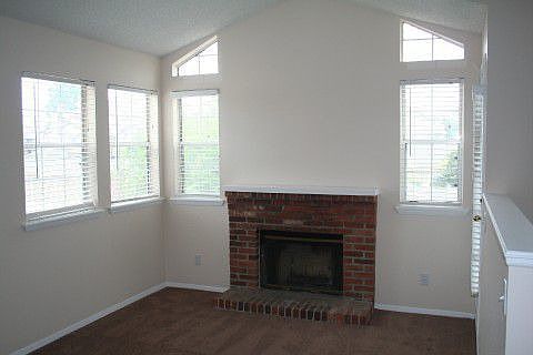 Living room has brick fireplace and lots of light