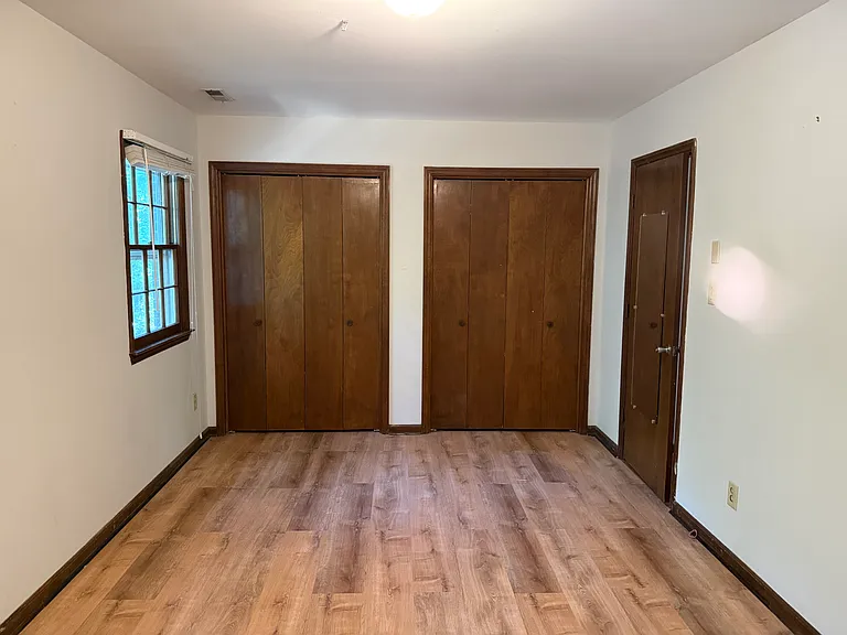 Bedroom on 2nd floor toward the back of the house: LVP floors, two windows, and twin closets.