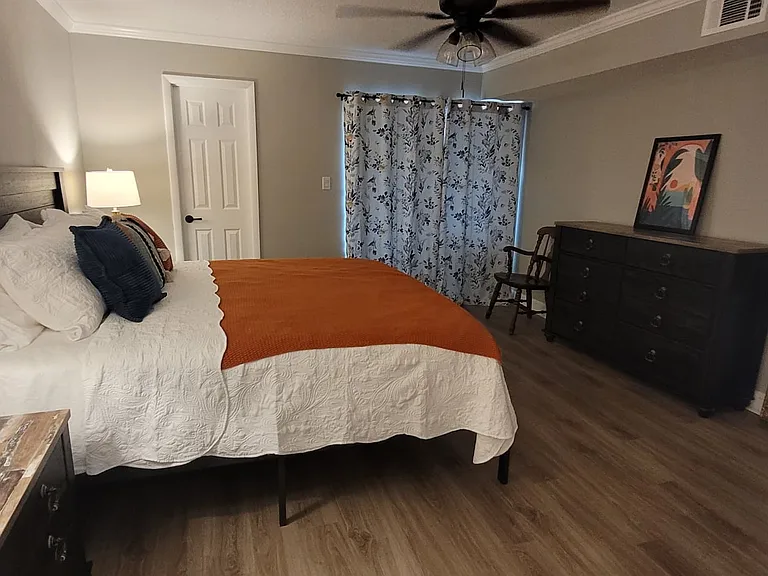 Primary bedroom with king sized bed, 2 nightstands and full sized dresser. All furniture is brand new.