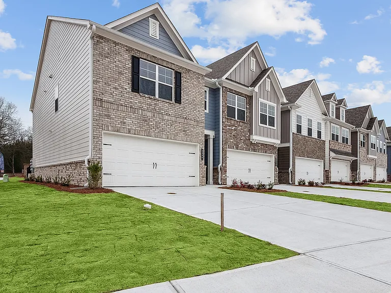 Side view of Carlton Crossing with a private driveway and attached garage.
