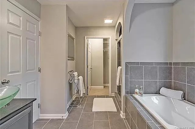 Primary bath, tub, shower, with one of the closets
