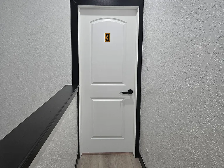 Clean interior hallway with durable flooring and a private access to bedroom 3
