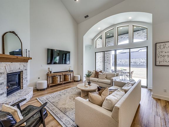 The family room is just briming with architectural interest and flooded with natural light. The amazing tall arched window structure includes sliding doors that open to the patio. A soaring vaulted ceiling adds appeal and a cozy fireplace is a nice focal pint in the room.