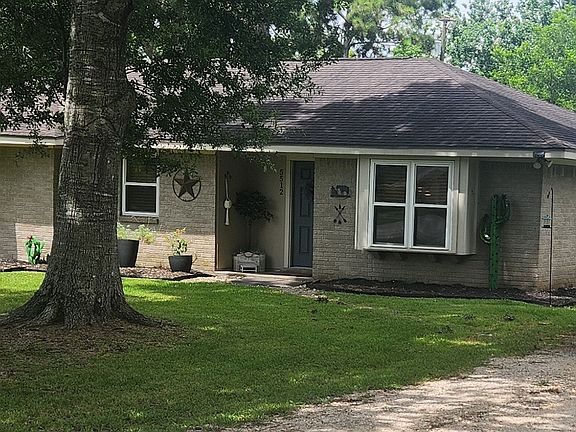 Charming single-story home with mature shade trees and a welcoming large drive way.