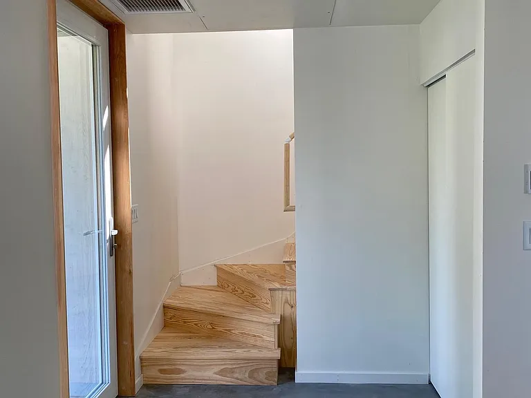 Entryway. Hall closet at left; sliding doors. Stairway up to second floor.