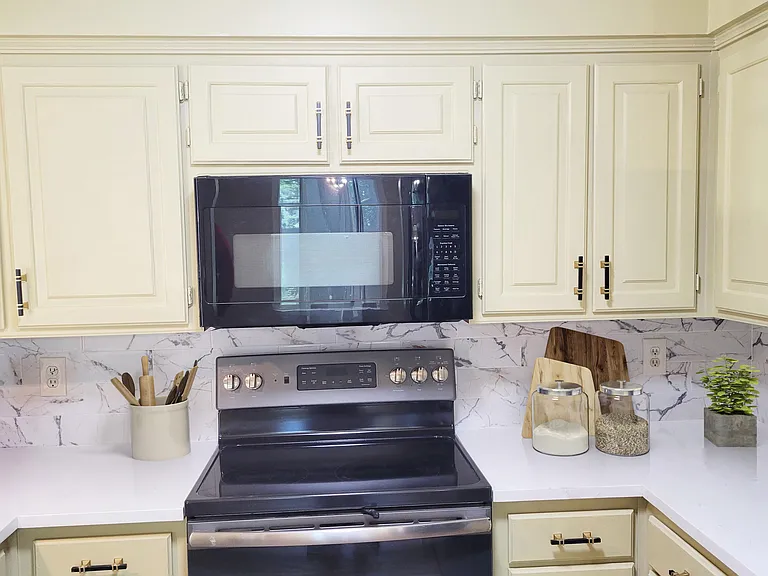 New quartz countertops and backsplash in kitchen. Matching black appliances, large and deep composite new granite sink and matching faucet. Large refrigerator and good cabinet space.