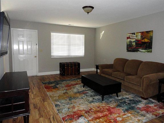 Living room with new wooden blinds and flooring.