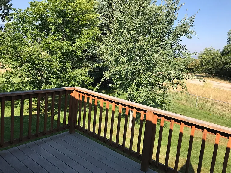 Deck off the kitchen with stairs to the grass.
