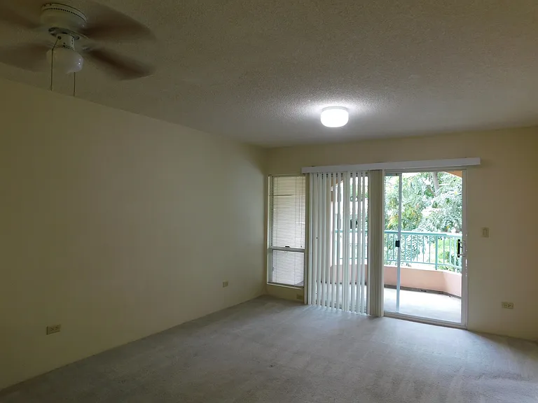 Living area with lanai (and storage closet). Ceiling fan. Carpet.