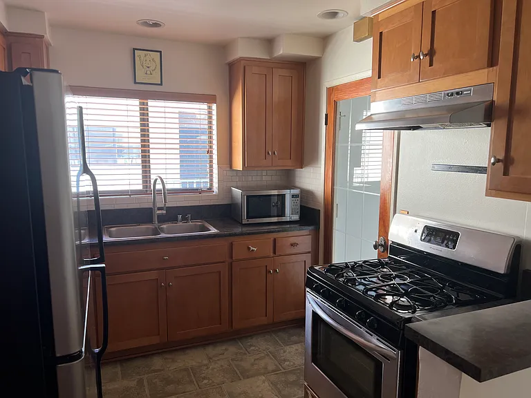 Microwave, refrigerator, stove with vent, oven + wooden cabinets