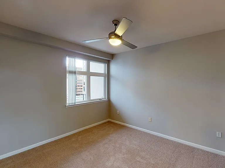 Spacious apartment bedroom with plush carpet flooring