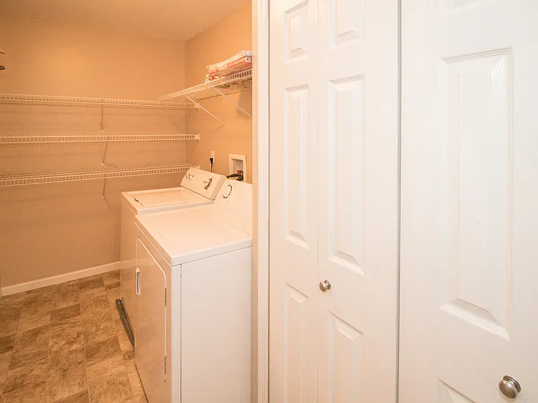 Over-sized laundry room with a full size washer and dryer, and plenty of storage