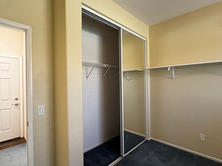 Bedroom#2: long, mirrored closet, wall shelf, carpet throughout