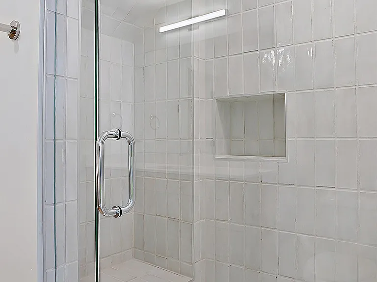 A glass-enclosed shower with clean, modern tile.