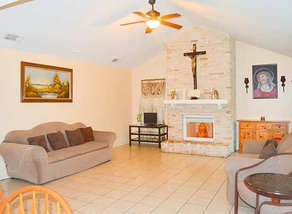 View of the living room from the back door/dining area. All tile throughout the home and smooth finished drywall.