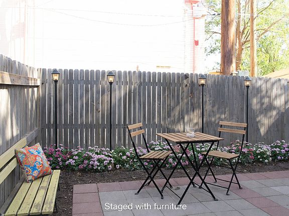 Tree shaded privacy fenced patio with room for outdoor living and dining