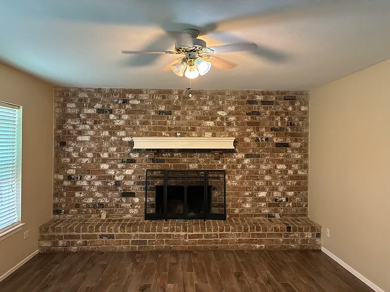 Downstairs livingroom hearth with gas woodburning fireplace.