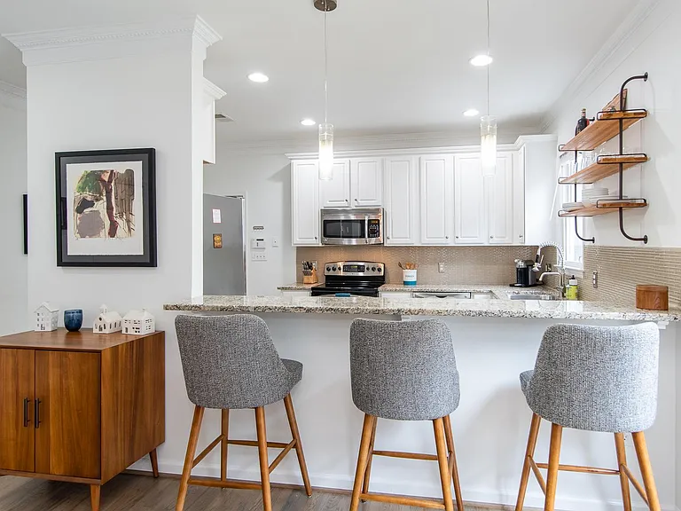 Kitchen has breakfast bar & view to living