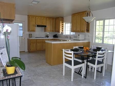 Kitchen offers marble flooring, wood cabinetry & built-in appliances