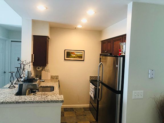Kitchen with stainless steel appliances, granite countertops, stone tile