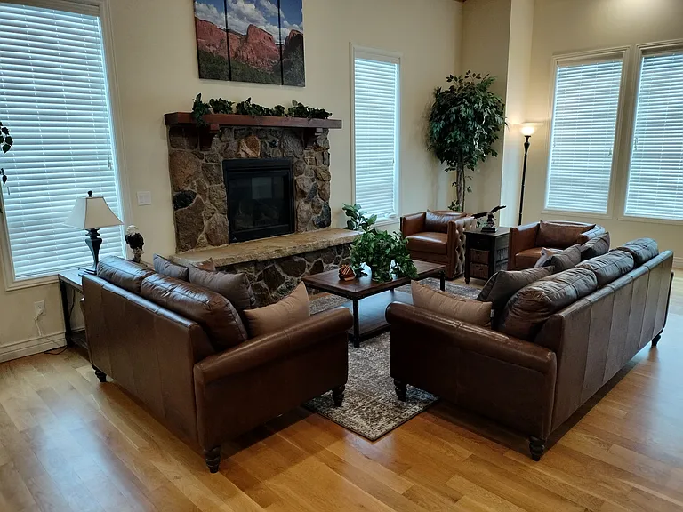 Stunning mountain views of Nordic Valley Ski Resort from your spacious living room. This inviting space features large windows for natural light, a cozy fireplace, recessed lighting, and a ceiling fan, creating the perfect atmosphere for relaxation