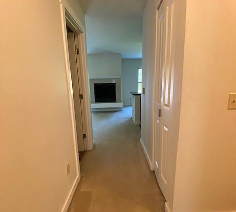 Hallway to Living, Dining, Kitchen. Bathroom door on the left. Plus additional storage closet on the right.