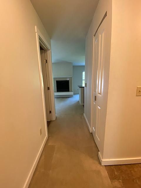 Hallway to Living, Dining, Kitchen. Bathroom door on the left. Plus additional storage closet on the right.