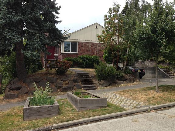 Front of house with raised garden beds and driveway