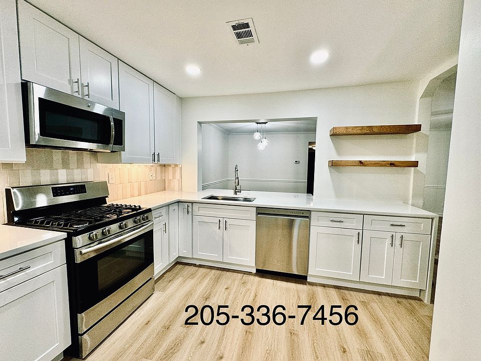 Prepare meals easily in this newly renovated kitchen with quartz countertop, tile backsplash, wooden shelves, new stainless steel appliances and new luxury vinyl plank flooring