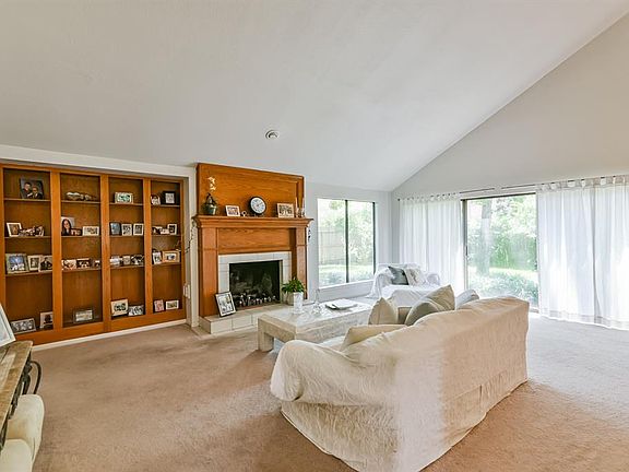 22x15 Family Room - Lots of windows, built-in shelving and gas fireplace with wood surround are features of the space along with a vaulted ceiling.
