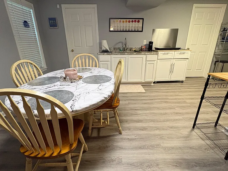 Eat-in kitchen with a dinette set, ample white cabinetry, durable counters, and a sink workspace for daily meal prep.