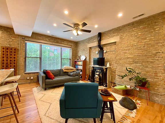 exposed brick living room with large windows and functional gas fireplace