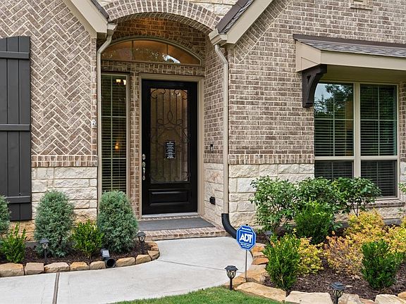 Gorgeous upgraded stone and brick elevation with 8' glass and wrought iron mahogany door.