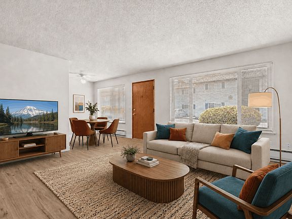 Spacious living room with a dedicated dining area in a one-bedroom deluxe apartment at Palisades Apartments in Tacoma.